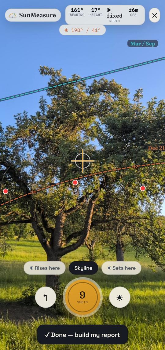 The SunMeasure AR sun scan running on a phone: the live orchard camera view with the app's sun-path arcs, crosshair, instrument readouts and capture controls overlaid edge to edge.
